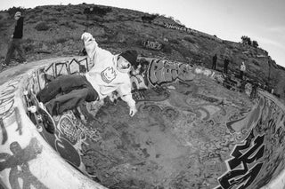 A skateboarder riding in a pool.