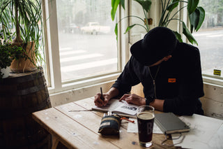 A man sketching with the Bolen titanium twist pen.