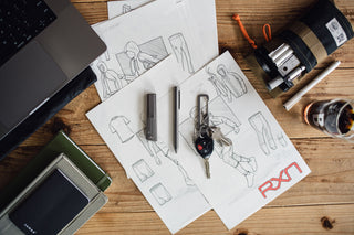 The Bolen titanium twist pen with other EDC items on a desk.
