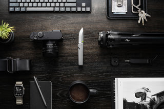 The Chapter 2 knife open on a desk with other accessories.