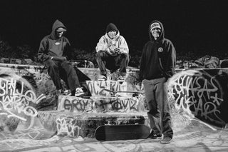 Three skaters taking a break at the Nude Bowl.